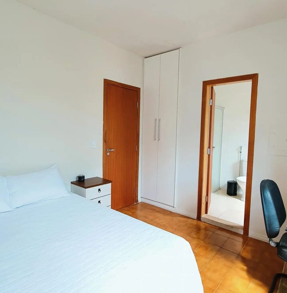 Suíte da Mangabeiras: cama, guarda-roupa e porta do banheiro